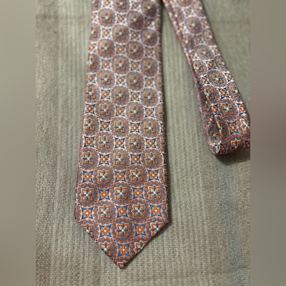 Cape Cod Neckwear 100% silk tie with an orange, gold and blue geometric pattern
